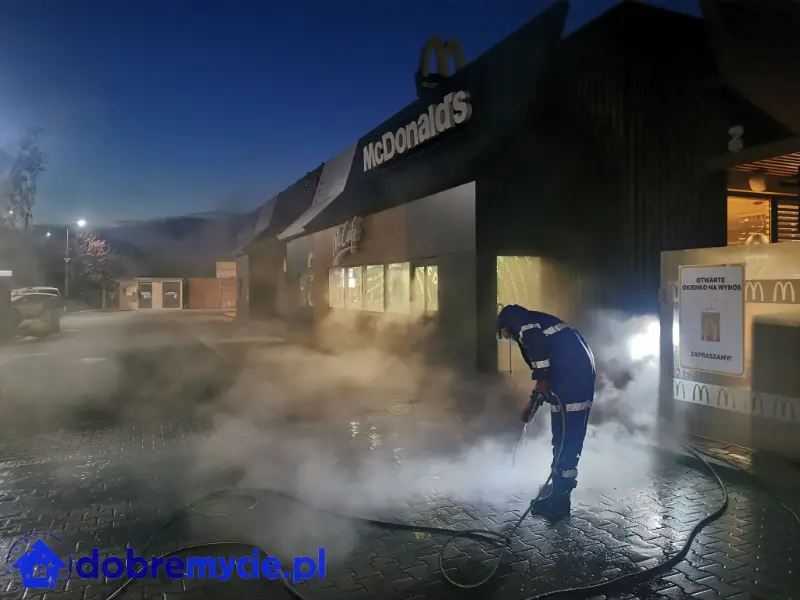 Mycie koski brukowej gorącą wodą. Widać jak unosi się para podczas mycia.